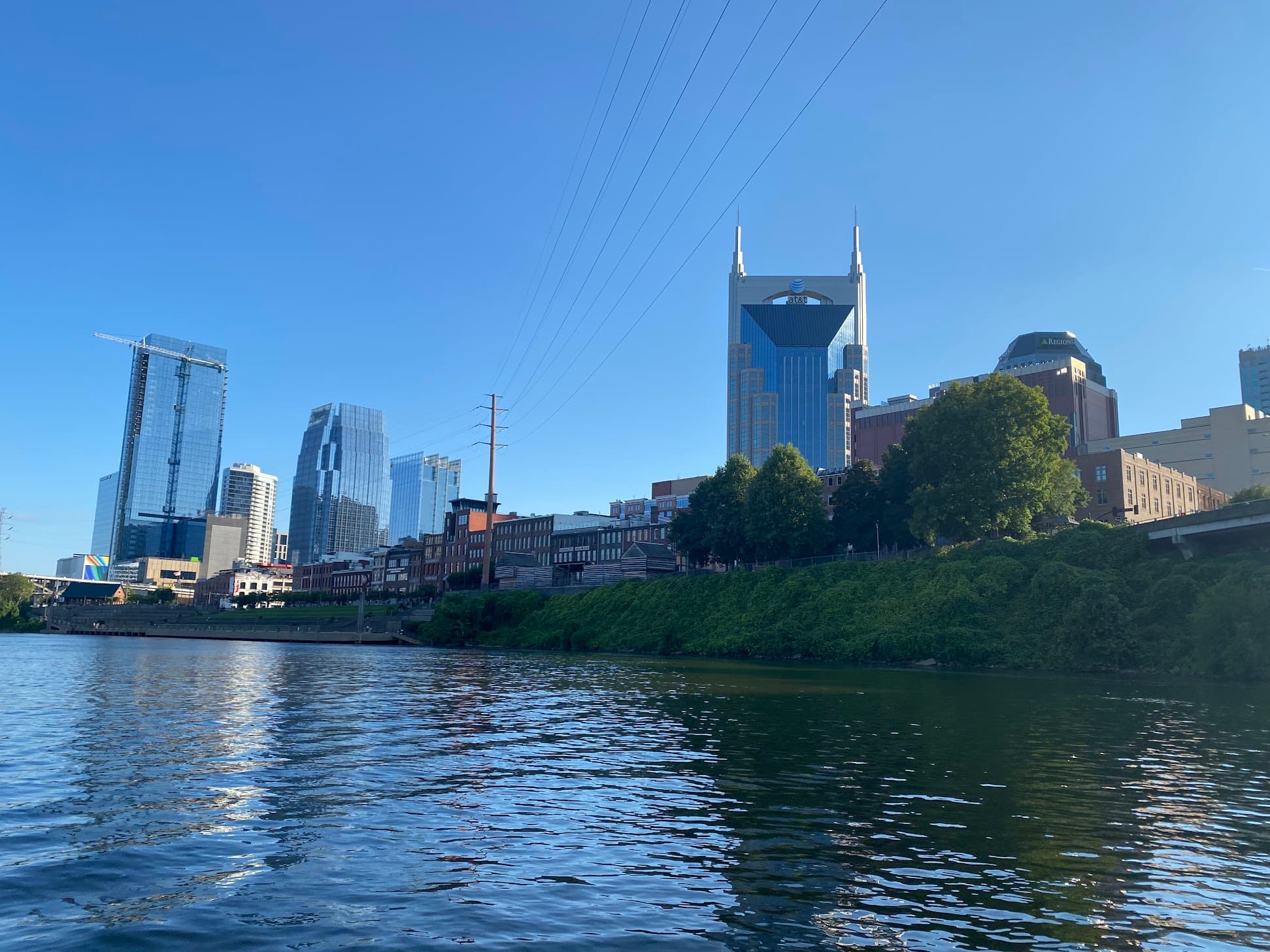 Nashville skyline featuring the AT&T Building viewed from the Cumberland River under a clear sky.
